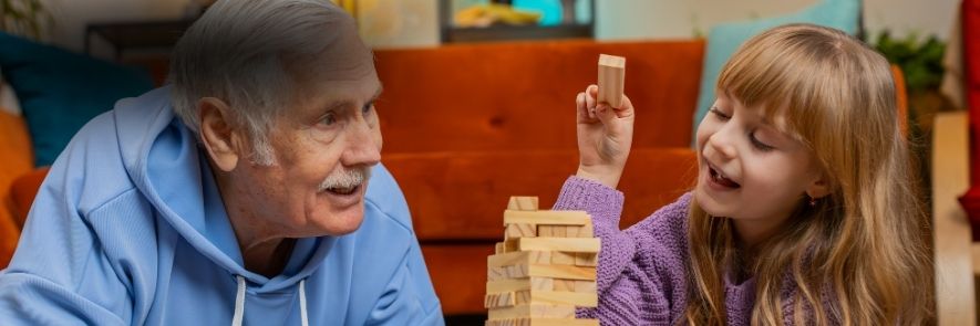 grand-père et sa petite fille jouant à un jeu de construction